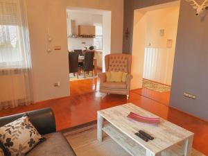 a living room with a coffee table and a chair at Adel Apartman in Miskolc