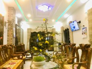 a room with chairs and a table with yellow flowers at Quang Vinh - Đảo Lý Sơn in Ly Son