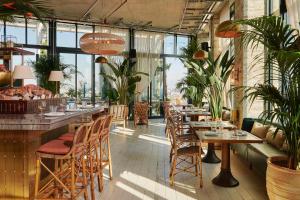 a restaurant with tables and chairs and plants at The Hoxton, Southwark in London