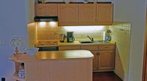 a kitchen with wooden cabinets and a counter top at Gschwendtner-Hof Ferienhof mit Wildgehege in Schleching