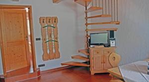 a room with a staircase and a television and a door at Gschwendtner-Hof Ferienhof mit Wildgehege in Schleching