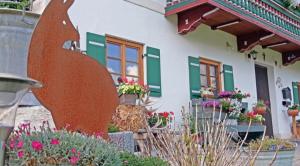 a house with a statue of a bird in front of it at Gschwendtner-Hof Ferienhof mit Wildgehege in Schleching