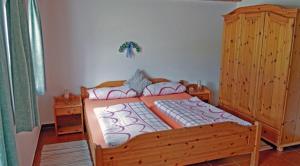 Schlafzimmer mit einem Holzbett und einem Holzschrank in der Unterkunft Gschwendtner-Hof Ferienhof mit Wildgehege in Schleching