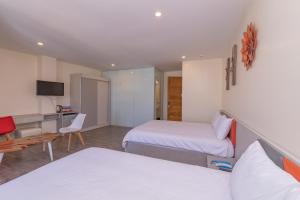 una camera d'albergo con due letti e una scrivania di Tường Vy 2 Hotel a Da Lat