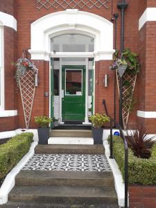 uma porta verde numa casa de tijolos vermelhos em Edendale House em Southport