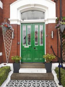 una puerta verde en una casa de ladrillo en Edendale House en Southport