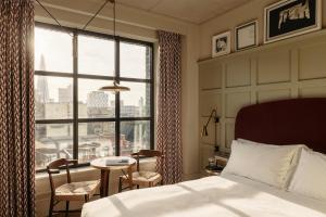 a hotel room with a bed and a large window at The Hoxton, Southwark in London