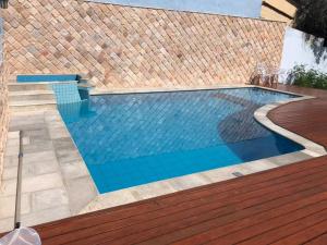 a swimming pool with a wooden deck and a swimming poolvisor at Loft Vila do Sossego in Pirenópolis