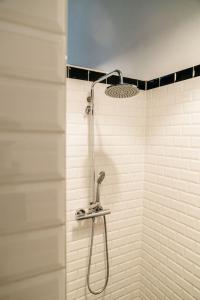 a shower with a shower head in a bathroom at Spui apartment in center in Amsterdam
