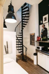 a black spiral staircase in a room with a bed at Spui apartment in center in Amsterdam