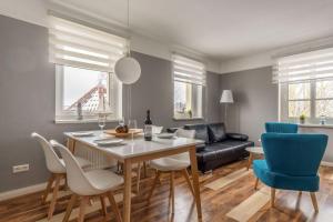 ein Esszimmer und ein Wohnzimmer mit Tisch und Stühlen in der Unterkunft Haus Godewind Typ 4 in Binz