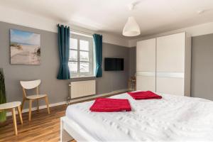 ein Schlafzimmer mit einem weißen Bett mit roten Handtüchern darauf in der Unterkunft Haus Godewind Typ 4 in Binz