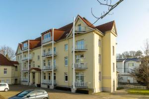 ein großes Apartmenthaus mit einem Auto vor dem Haus in der Unterkunft Haus Godewind Typ 4 in Binz