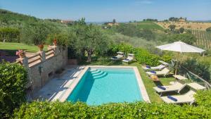 una piscina con tumbonas y sombrilla en L'Oliveta 6, Emma Villas, en Gambassi Terme