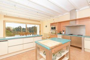 a large kitchen with white cabinets and a large window at Villa Tarifa in Tarifa
