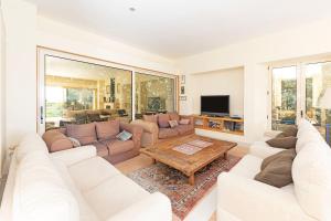 a living room with white furniture and a large window at Villa Tarifa in Tarifa