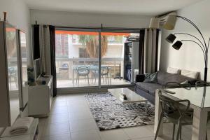 a living room with a couch and a table at app Le Rocazur avec piscine et parking en bord de mer à 500M du centre ville in Menton