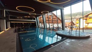 a swimming pool with a table in a building at Hotel Meta Resort & Vine SPA in Szczyrk
