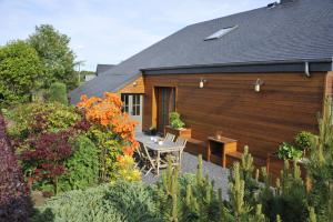 una casa de madera con una mesa en un jardín en Le Clos Sigebert, en Libramont