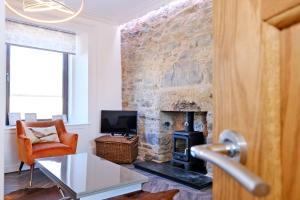a living room with a stone wall with a fireplace at Ben Shea Smart Home in Dufftown