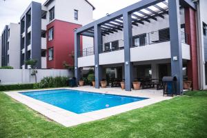 an apartment with a swimming pool in front of a building at Residence at Montego in Sandton