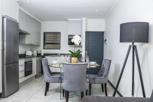 a dining room with a table and chairs and a kitchen at Residence at Montego in Sandton