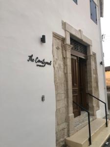 a sign on the side of a white building at The Courtyard Episkopi Guest Houses in Episkopi Limassol