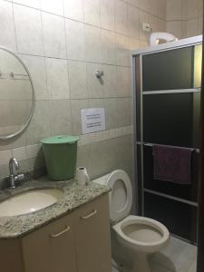 Un baño con inodoro, lavabo y espejo. en Sobrado 03 na Praia de Bombas, en Bombinhas 33 fotos más