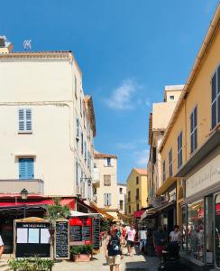 a group of people walking down a street with buildings at Grand Hôtel De Calvi in Calvi