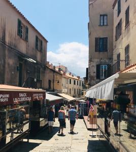 a group of people walking down a street in a market at Grand Hôtel De Calvi in Calvi