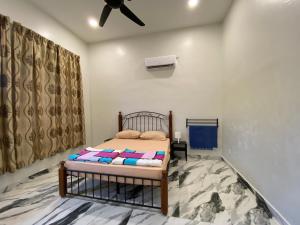 Bangi Utara Villa في كاجانغ: غرفة نوم بسرير ومروحة سقف