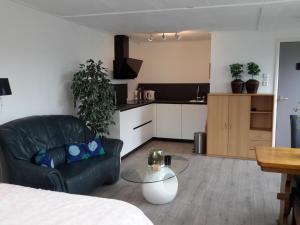 ein Wohnzimmer mit einem schwarzen Sofa und einem Tisch in der Unterkunft Strandhuussie Texel in De Koog