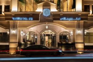 une voiture garée devant un bâtiment la nuit dans l'établissement Vittori Palace Hotel and Residences, à Riyad