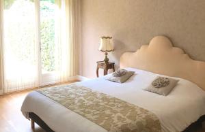 a bedroom with a large white bed with two pillows at Auberge Les Hauts De Chenas in Chénas