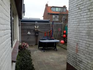 a patio with a table in a yard with balloons at Strandhuussie Texel in De Koog