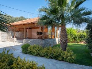 una casa con una palmera delante de ella en Luxurious Villa David, en Áno Kalésia