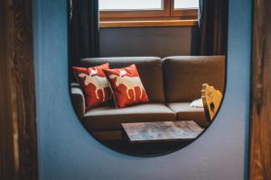 a mirror reflection of a couch with pillows and a table at Nordic Lodge in Bad Kleinkirchheim