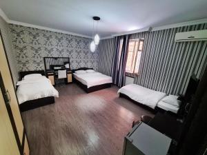 a bedroom with two beds and a desk in it at Chveni sakhli in Tbilisi City
