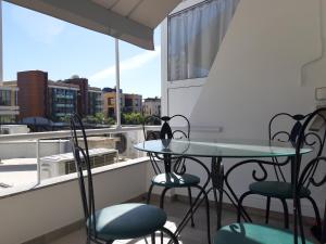 a balcony with two tables and chairs and a window at Sun sea B102 apartment by the beach in Limassol