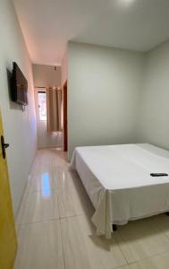 ein Schlafzimmer mit einem großen weißen Bett in einem Zimmer in der Unterkunft Hotel Pousada Aeroporto in Ponta Porã