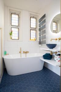 uma casa de banho branca com uma banheira e um lavatório em B&B d'Ouwe Grutter em Wagenberg