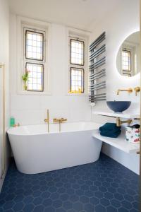 a white bathroom with a tub and a sink at B&B d'Ouwe Grutter in Wagenberg