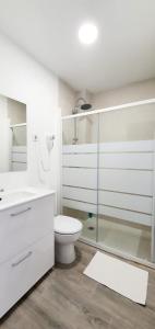 biała łazienka z toaletą i przeszkloną kabiną prysznicową w obiekcie Suite by Hawkins Atico w mieście Algeciras