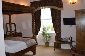 a bedroom with a canopy bed and a window at Brigands Inn in Mallwyd