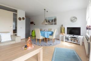 a living room with a blue table and a tv at Residence Juliana appartement 65 - Julianadorp aan zee in Julianadorp