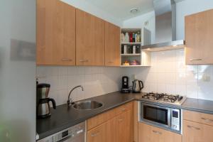 a kitchen with a sink and a stove top oven at Residence Juliana appartement 65 - Julianadorp aan zee in Julianadorp