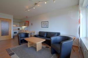 ein Wohnzimmer mit einer Couch und Stühlen und einem Tisch in der Unterkunft Apartment 255 in Hohegeiß