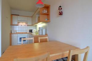 eine Küche mit einem Holztisch und einem Tisch und Stühlen in der Unterkunft Apartment 255 in Hohegeiß