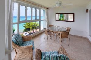 a dining room with a table and chairs and the ocean at Beach View Hotel in Saint James