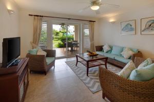 a living room with a couch and chairs and a tv at Beach View Hotel in Saint James